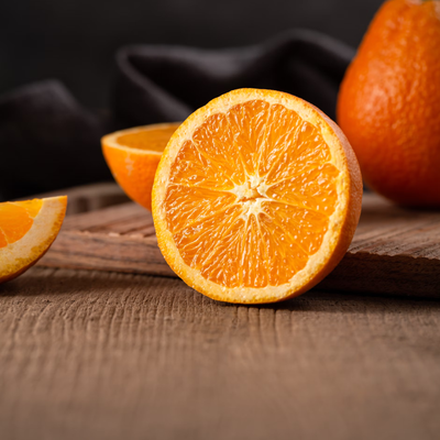 Halved orange on a wooden board, illustrating a Vegetology article on vitamin C