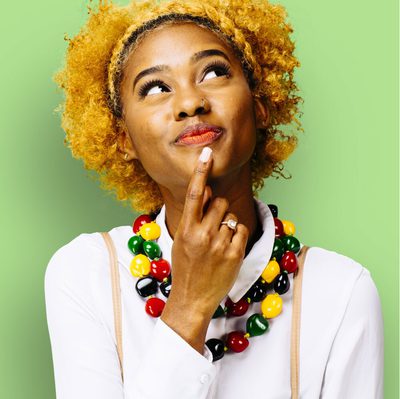A woman with a thoughtful expression against a green background
